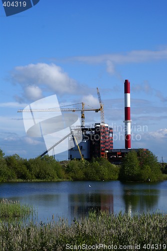 Image of construction in industrial factory  with lake and blue sky on ba