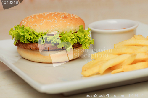 Image of classic burger with French fries on the table in a cafe