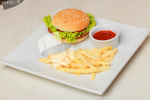 Image of classic burger with French fries on the table in a cafe