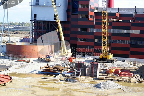 Image of cranes and chinmey on construction of industrial factory