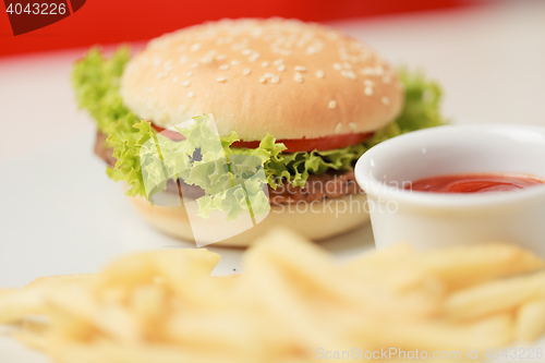Image of classic burger with French fries on the table in a cafe