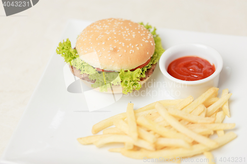 Image of classic burger with French fries on the table in a cafe