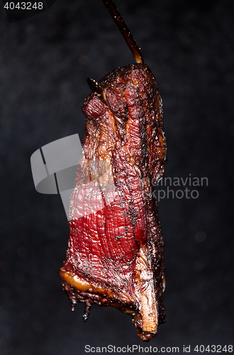 Image of Smoking pork neck in home smokehouse