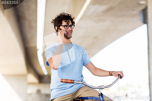 Image of man with smartphone and fixed gear bike on street