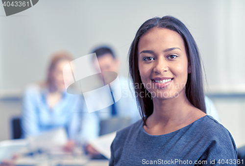 Image of group of smiling businesspeople meeting in office