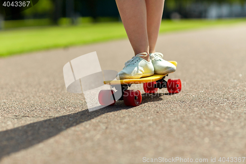 Image of close up of female feet riding short skateboard