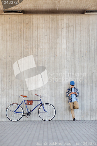 Image of man with smartphone, earphones and bicycle