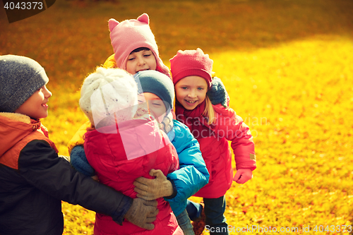 Image of group of happy children hugging in autumn park