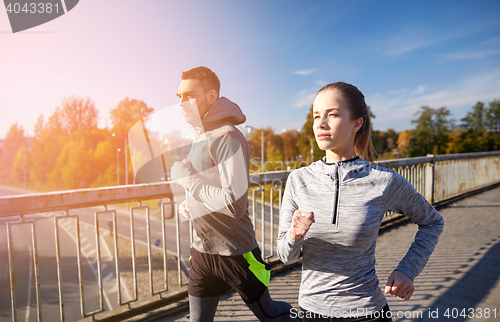 Image of happy couple running outdoors