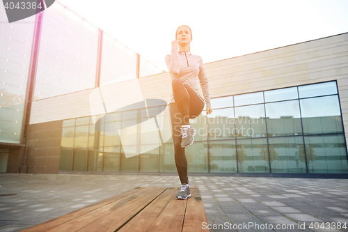 Image of woman making step exercise on city street bench