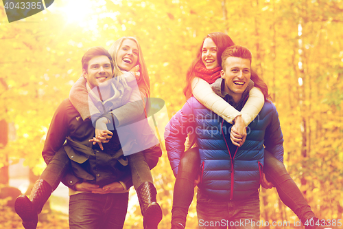 Image of smiling friends having fun in autumn park