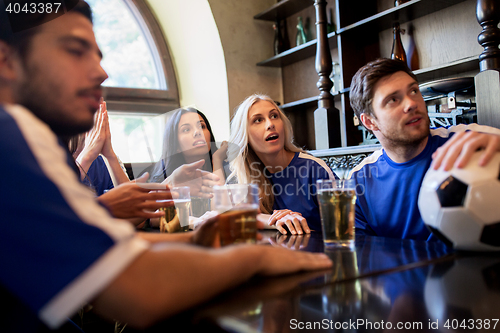 Image of fans or friends watching football at sport bar