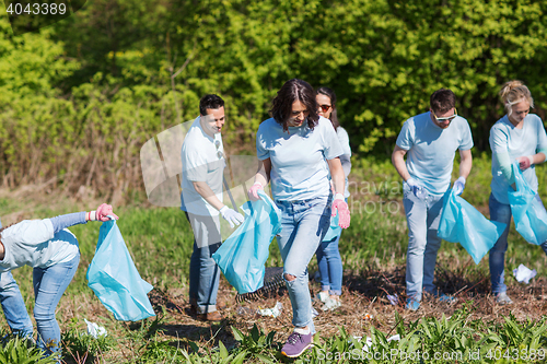 Image of volunteers with garbage bags cleaning park area