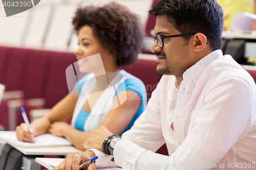 Image of international students with notebooks on lecture