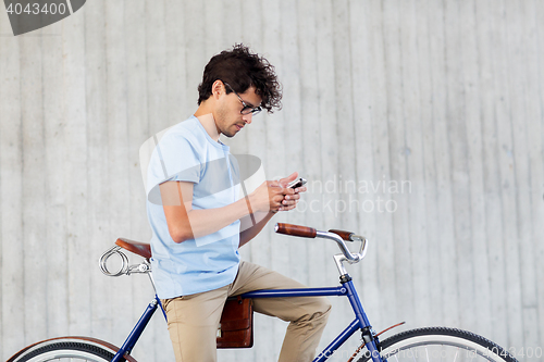 Image of man with smartphone and fixed gear bike on street