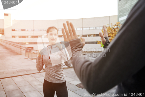 Image of woman with trainer working out self defense strike