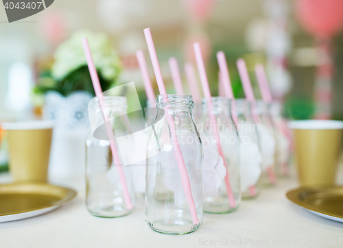 Image of close up of glass bottles for drinks with straws