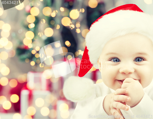 Image of happy baby in santa hat over christmas lights