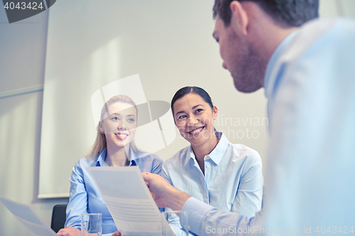 Image of group of smiling businesspeople meeting in office