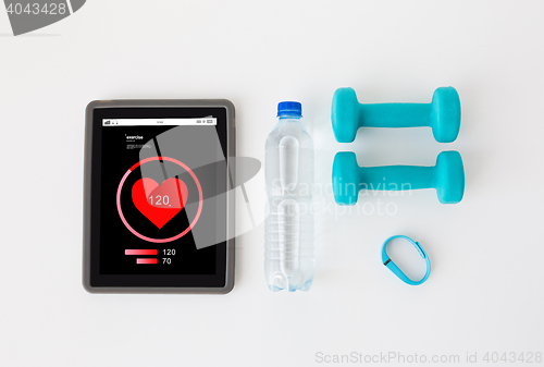 Image of tablet pc, dumbbells, fitness tracker and bottle