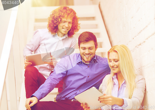 Image of team with tablet pc computer sitting on staircase