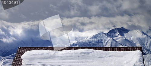 Image of Panoramic view on snowy roof and mountains in clouds