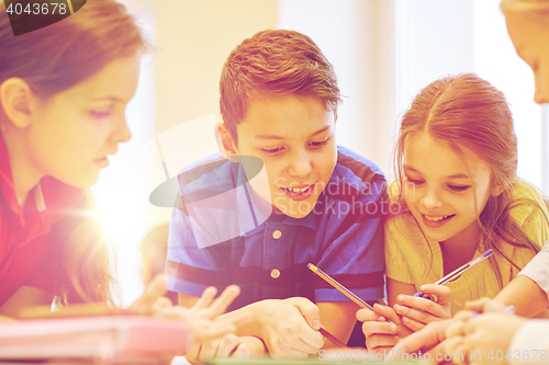 Image of group of students talking and writing at school