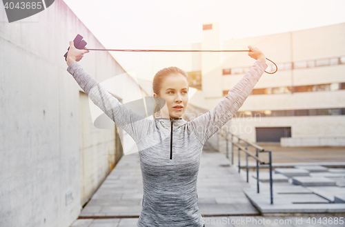 Image of woman exercising with jump-rope outdoors