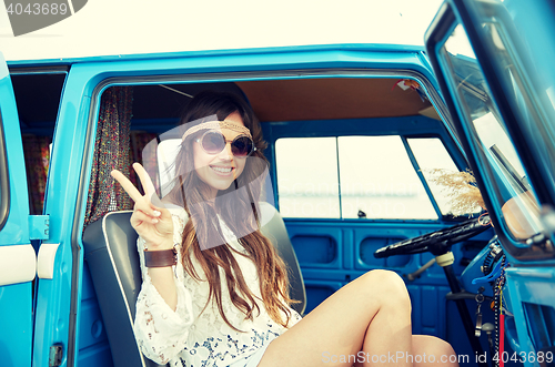 Image of happy hippie woman showing peace in minivan car