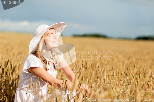 Image of happy young woman in sun hat on cereal field