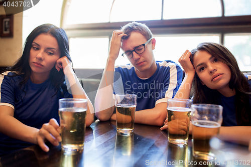 Image of soccer fans watching football match at bar or pub