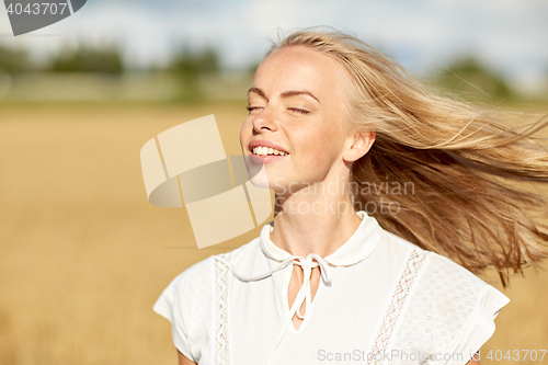 Image of smiling young woman in white on cereal field