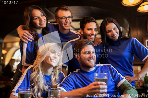 Image of football fans or friends with beer at sport bar