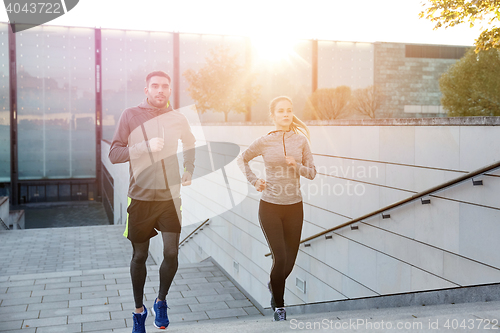 Image of happy couple running upstairs on city stairs