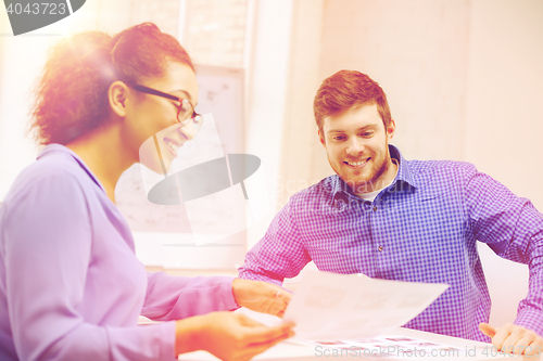 Image of smiling team with paper at office