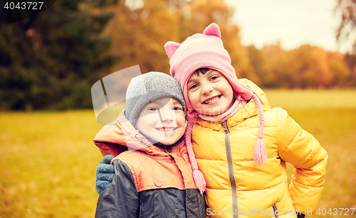 Image of happy little girl and boy in autumn park