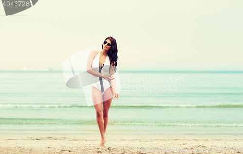 Image of young woman in swimsuit posing on beach