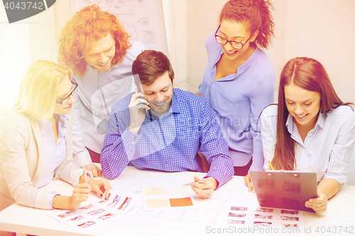 Image of creative team with papers and clipboard at office