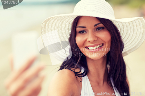 Image of young woman taking selfie with smartphone