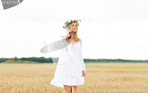 Image of happy young woman calling on smartphone at country