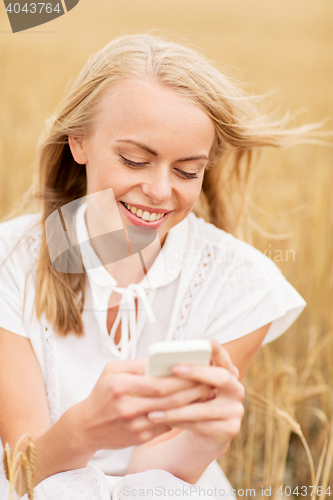 Image of happy young woman with smartphone on cereal field