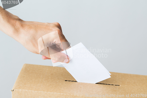 Image of man putting his vote into ballot box on election