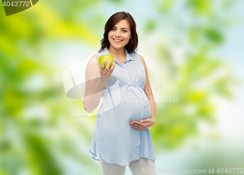 Image of happy pregnant woman holding green apple