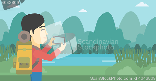 Image of Man with backpack taking photo.