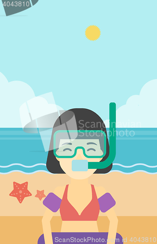 Image of Woman with snorkeling equipment on the beach.