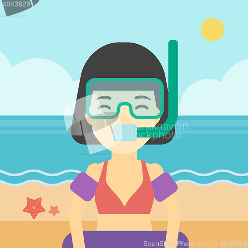 Image of Woman with snorkeling equipment on the beach.