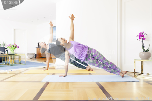 Image of two women doing yoga at home