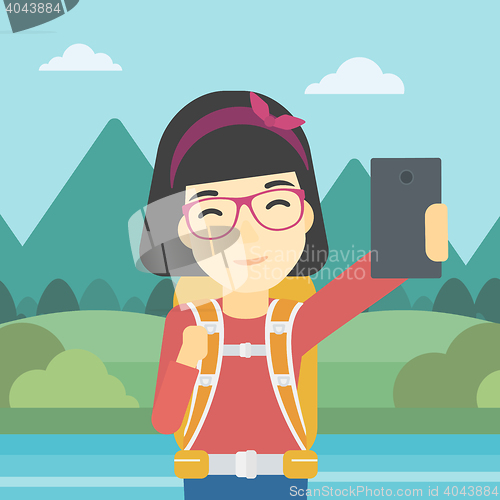 Image of Woman with backpack making selfie.