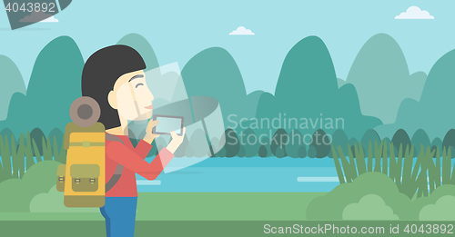 Image of Woman with backpack taking photo.