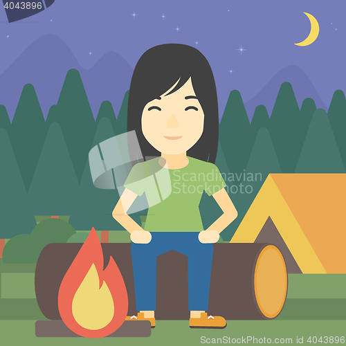 Image of Woman sitting on log in the camping.